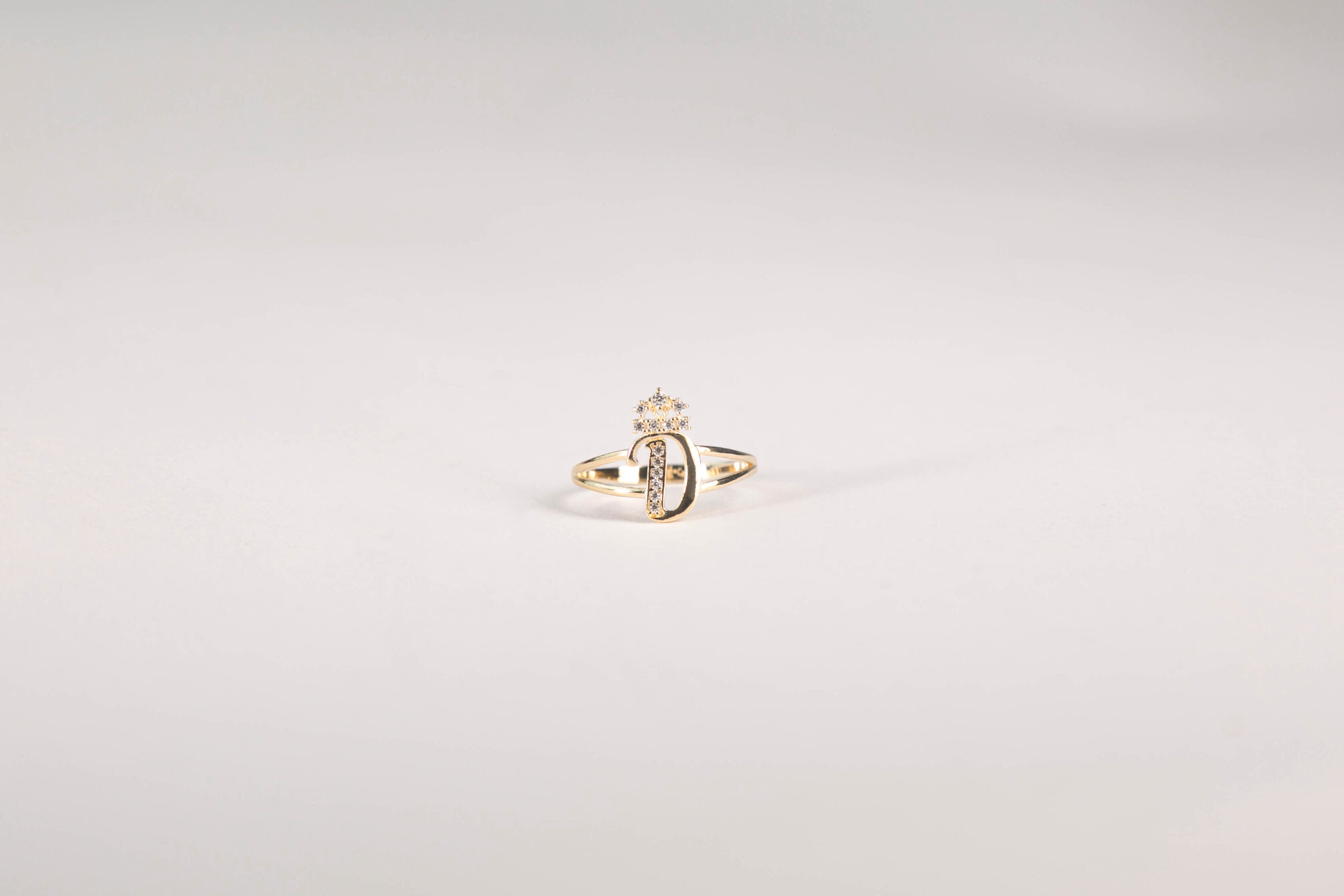 Gold ring with a diamond on a light gray background