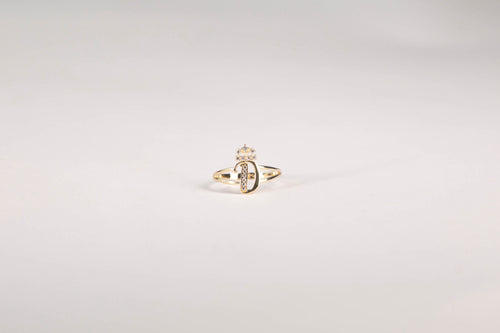Gold ring with a diamond on a light gray background